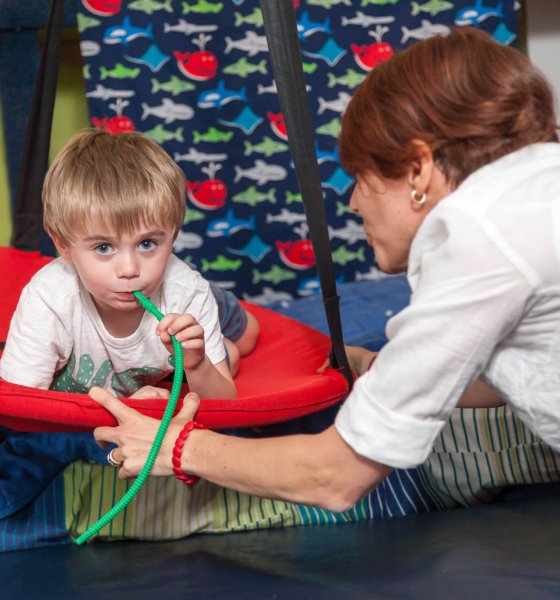 A child engaged in sensory play during a neuroaffirming therapy session